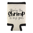 A beige can cooler with the phrase “You’re the Shrimp to My Grits,” standing on a white background.