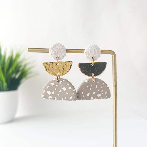 Pair of earrings on a stand with a white background
