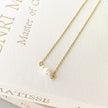 Gold necklace with a pearl pendant on a Matisse jewelry box