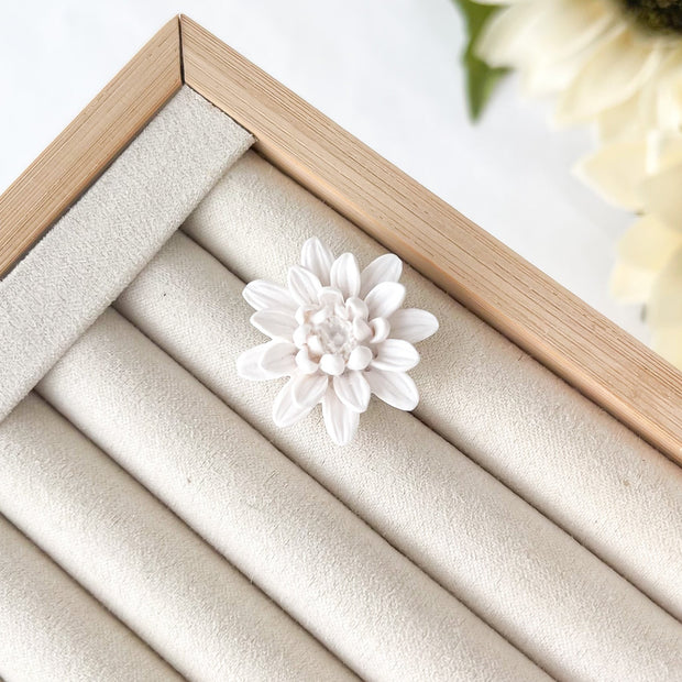 Close-up of a jewelry box with a white flower adjustable ring on a light background