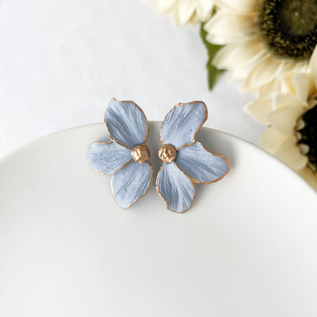 Periwinkle blue  boho floral polymer clay stud earrings with gold-tone accents on white background
