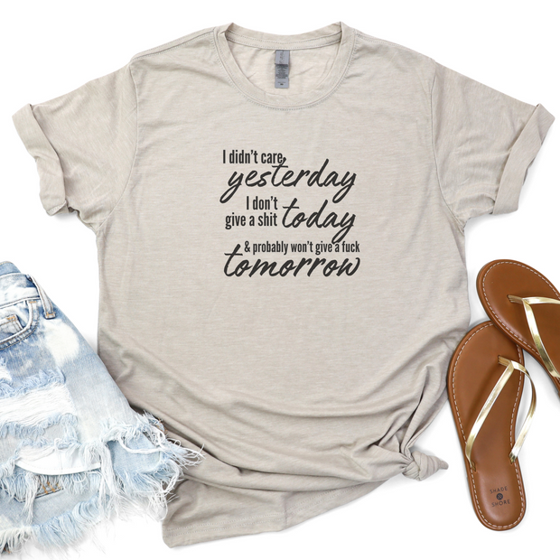 Beige t-shirt with text, denim shorts, and sandals on a white background