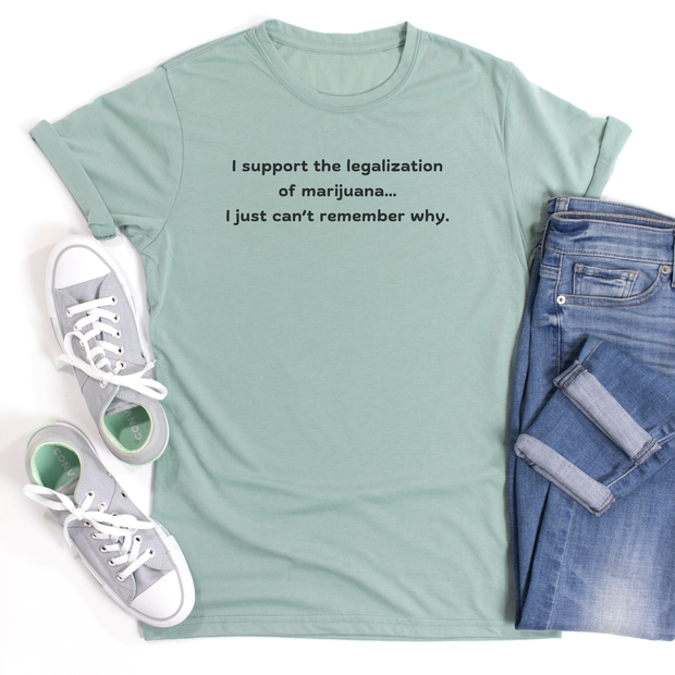 Light green t-shirt with text, " I support the legalization of marijuana I just cant remember why" with white sneakers, and blue jeans on a white background
