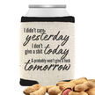 A beige can cooler with the phrase “I Didn’t Care Yesterday, I Don’t Give a Sh*t Today & Probably Won’t Tomorrow,” displayed on a white background with peanuts scattered in front of the can cooler.
