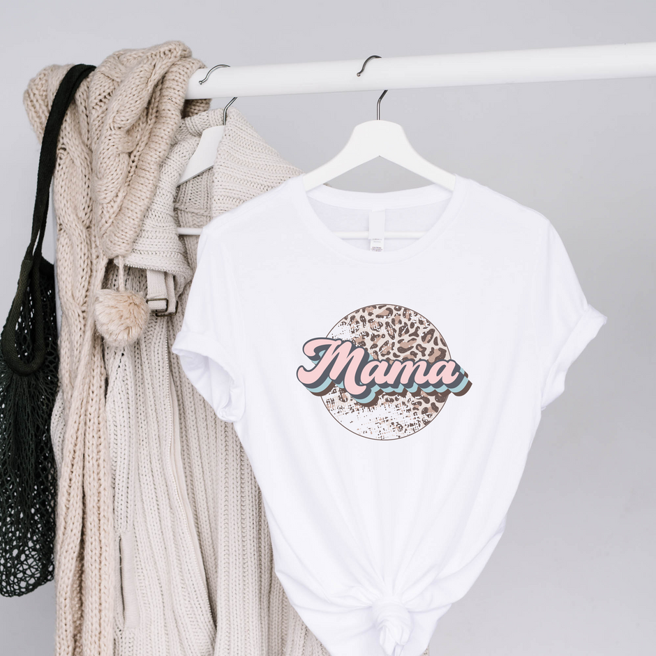 White t-shirt with 'Mama' print on a hanger against a gray background